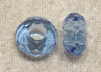 Facetterad transparent ljusblå glasrondell med stort hål