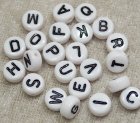 Bokstavspärlor, vita coins m svarta bokstäver, alfabetet